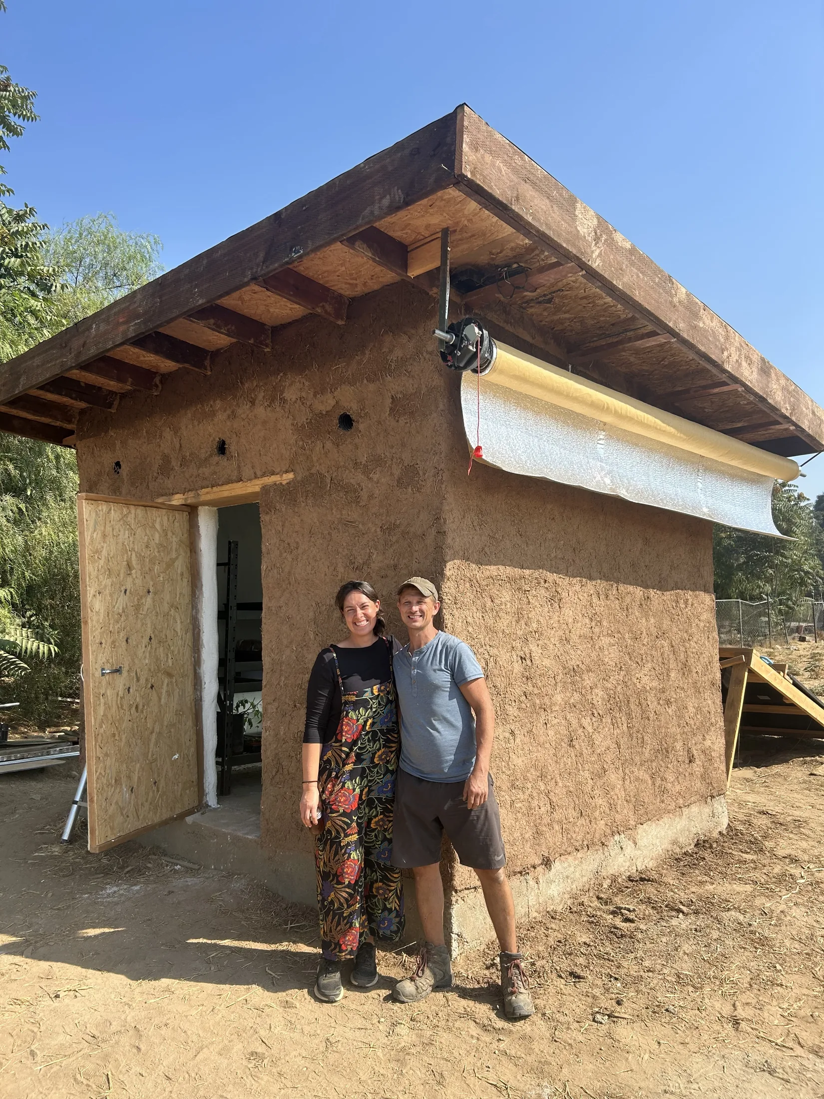 Gina and Rich standing beside a Littlest Big Farm they built